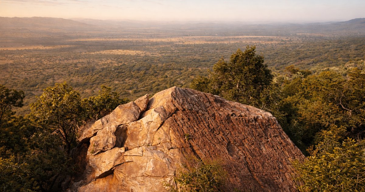 Ancient sandstone cliffs of the Magaliesberg at golden hour with two tiny hikers on a distant ridgeline.